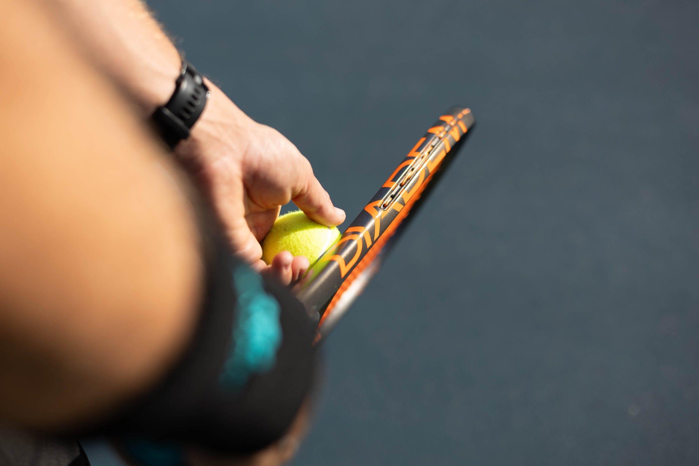 A player holding a Diadem Axis racket and a ball